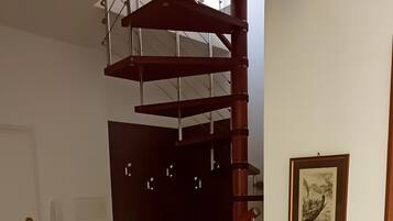 A spacious room with a spiral staircase leading to an upper floor.