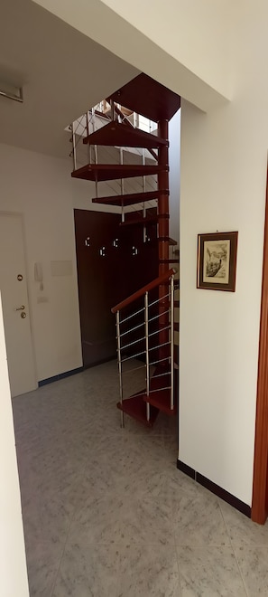 Une pièce spacieuse avec un escalier en colimaçon menant à l’étage supérieur.