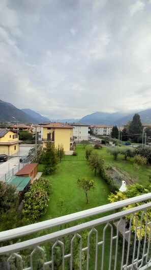 A residential area with houses, a green lawn, and mountains in the background. - Aurora Vacation Home: Between the Lake and the Mountains (Costa Volpino)