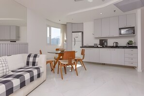 Un appartement moderne comprenant un coin repas, une cuisine et un espace de vie.