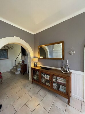 A hallway with a wooden console table, a mirror, and a staircase. - The Bastide of the Valleys (Murs)