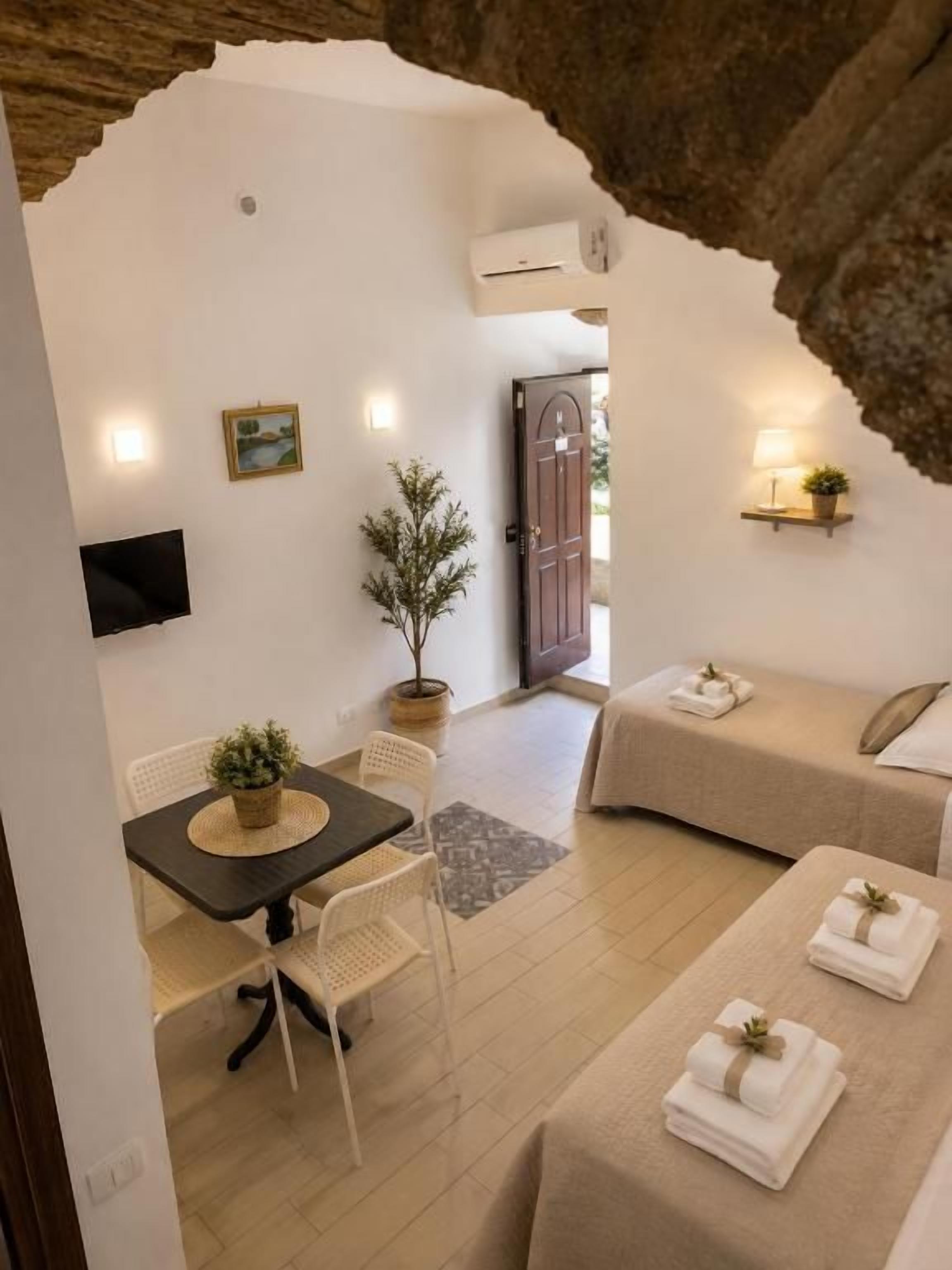 A cozy room with a dining table, chairs, a sofa, and a bed.