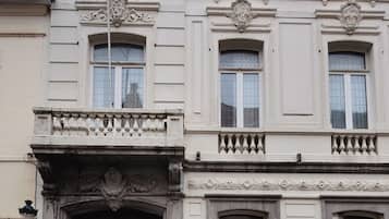 A multi-story building with a classical architectural style, featuring ornate window frames and a decorative entrance.