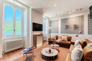 Un salon moderne avec un canapé, une table basse et un téléviseur à écran plat.