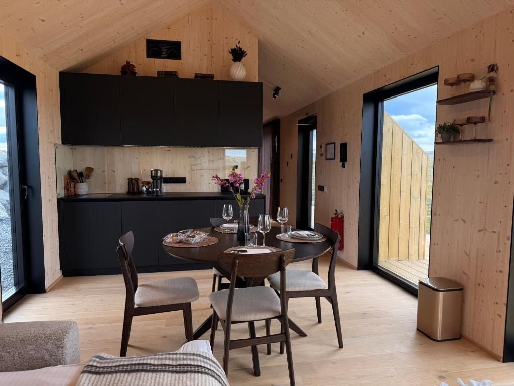 Een modern interieur met een eethoek, keuken en grote ramen.