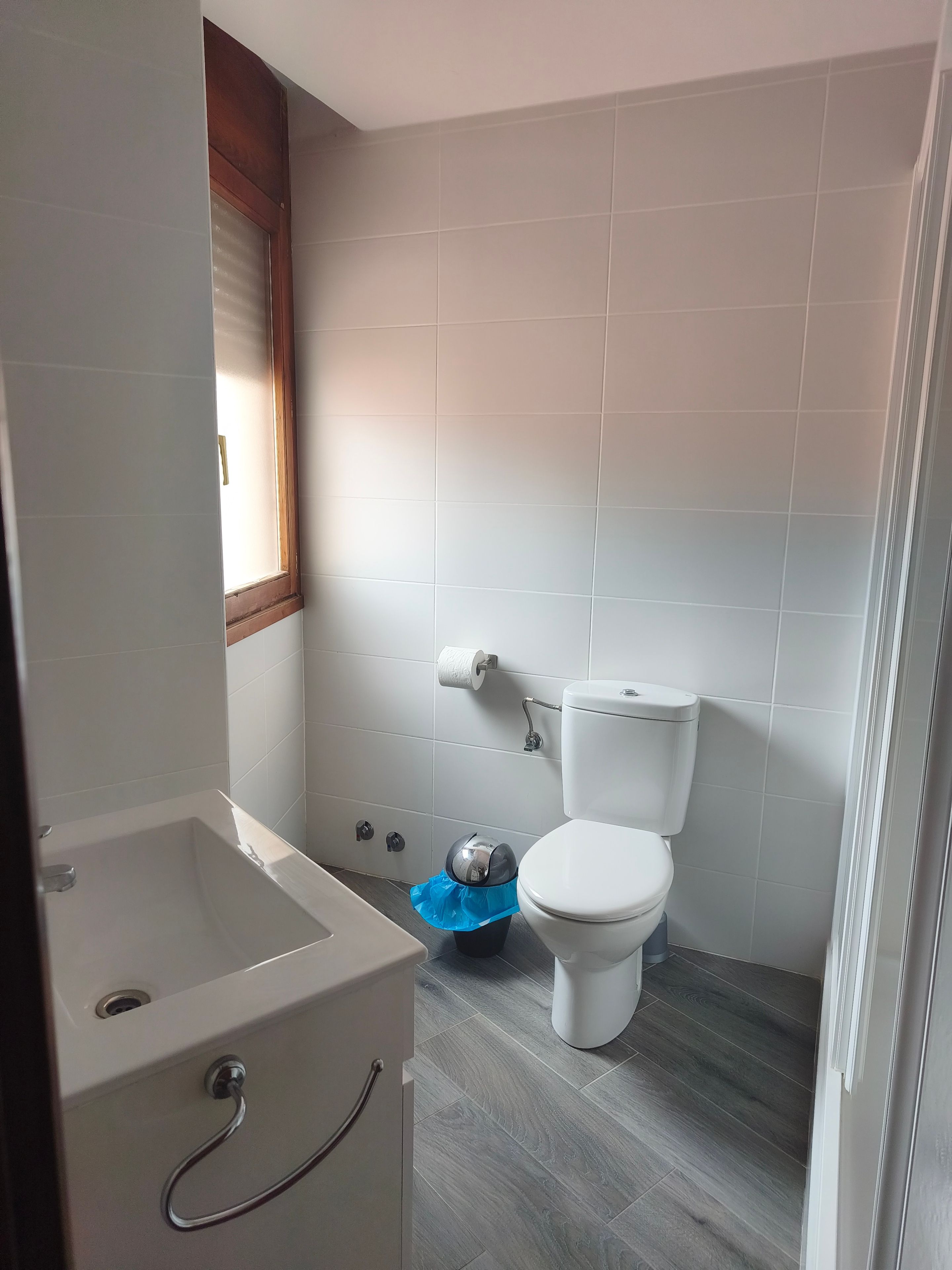 Un baño con bañera, inodoro y un cubo de basura.