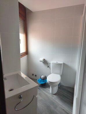 Un bagno con una vasca, un water e un cestino.