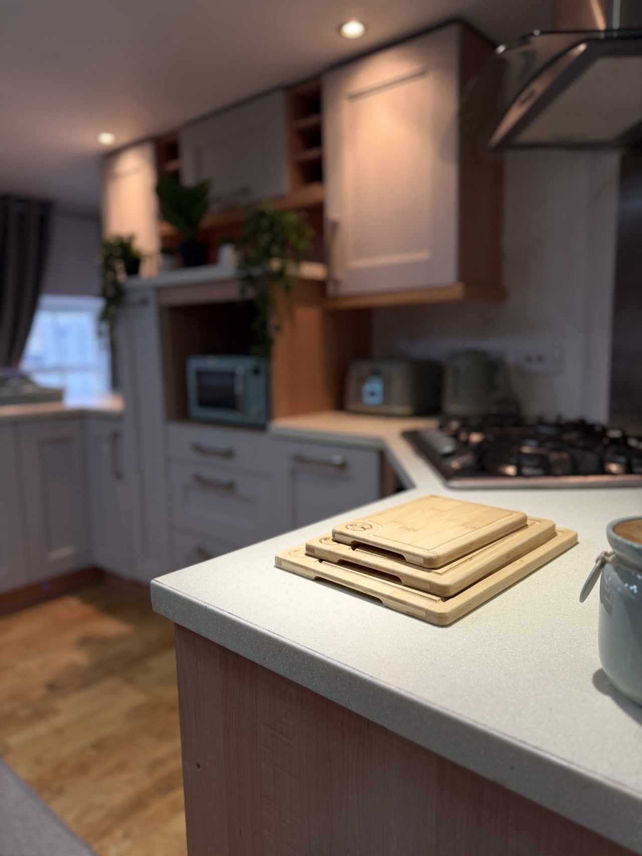 Una cocina moderna con encimera, tablas de cortar de madera, microondas y estufa.