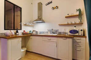 A compact kitchen with a microwave, a coffee maker, and a sink.