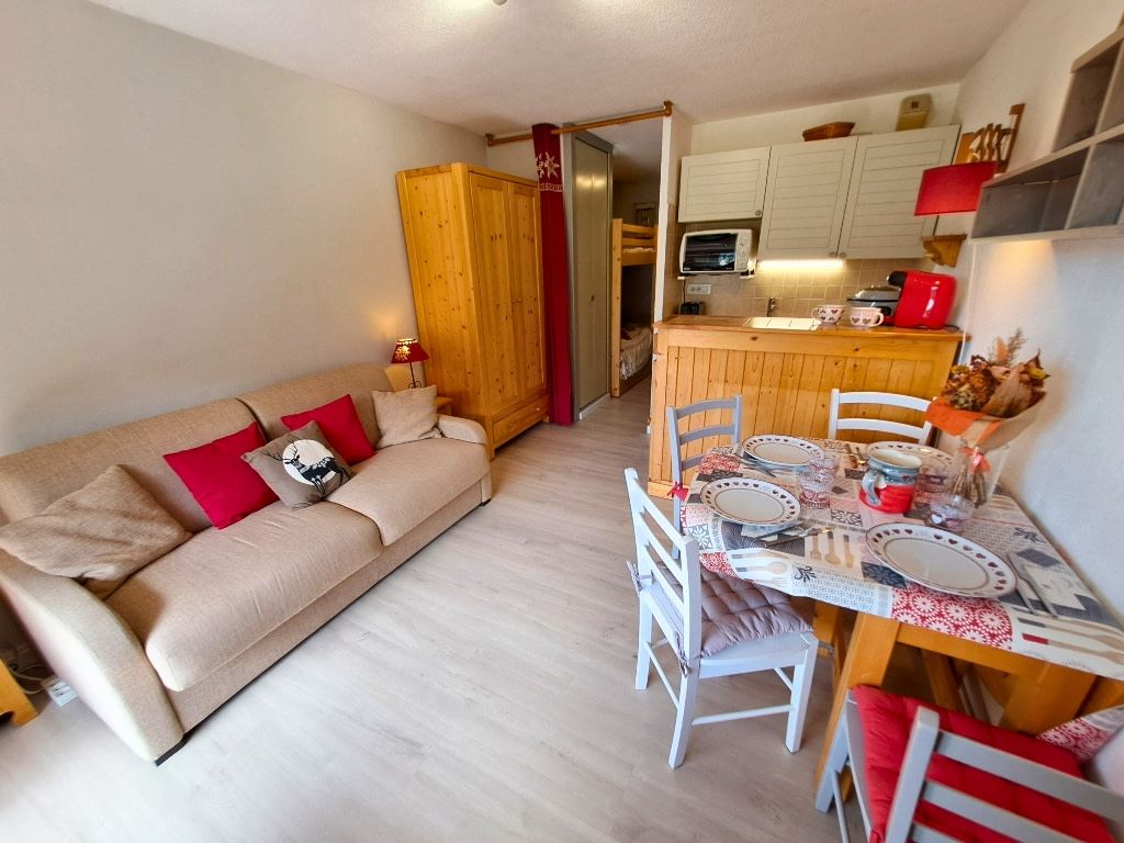 Un salon confortable avec un canapé, une table à manger et des chaises, ainsi qu’un coin cuisine équipé de placards et d’un four à micro-ondes.