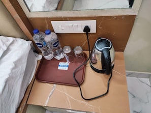 A kitchenette area with a kettle, water bottles, and a fast food sign. - Shri Hari Guesthouse (Varanasi)