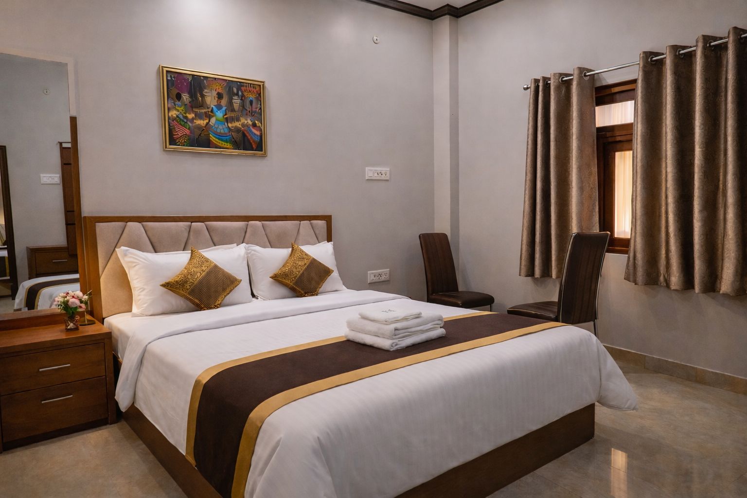 Una habitación de hotel con una cama grande, una mesita de noche, una silla, una ventana con cortinas y un cuadro en la pared.