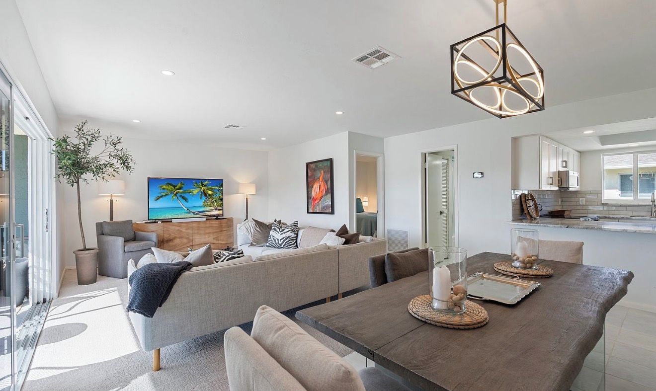 A modern living room with a sofa, dining table, and artwork.