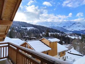 A wooden cabin with a balcony overlooking a snowy mountain landscape. - Ski aux pieds | Piscine Chauffée | Spa (Combloux)