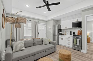 A modern kitchen with a built-in oven and a large TV. - Sandbox and Sunshine 8 (Margate City)