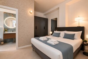 A modern hotel room with a large bed, a bedside table, a nightstand, a mirror, a wardrobe, and a bathroom with a sink and mirror. - Newly renovated apartment with a balcony, a 10-minute walk to Bocconi, sleeps 4 (Milan)