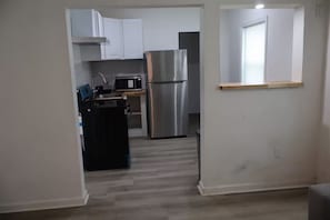 A kitchen with white cabinets, a stainless steel refrigerator, and a microwave. - Welcoming 1-bedroom apartment with AC in charming Palmetto (Palmetto)