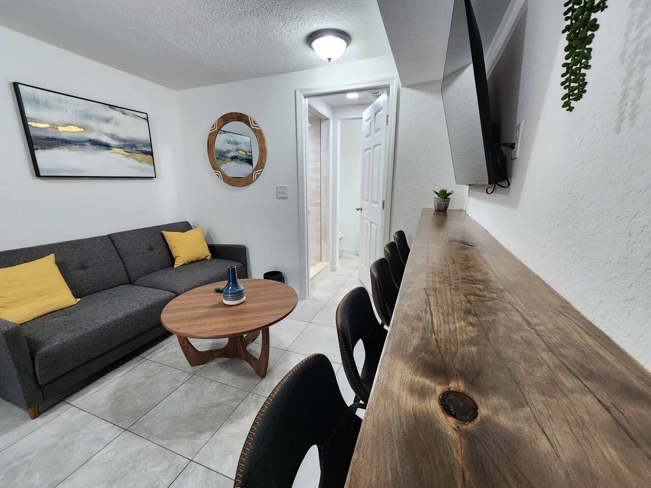 Een moderne woonkamer met een bank, salontafel en eethoek.