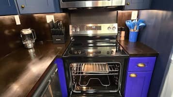 Une cuisine équipée d’un four à micro-ondes, d’un four et d’un lave-vaisselle, tous en acier inoxydable.