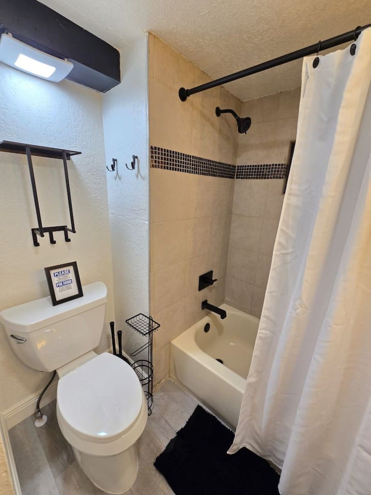 Une salle de bain avec des toilettes, une douche et une baignoire.