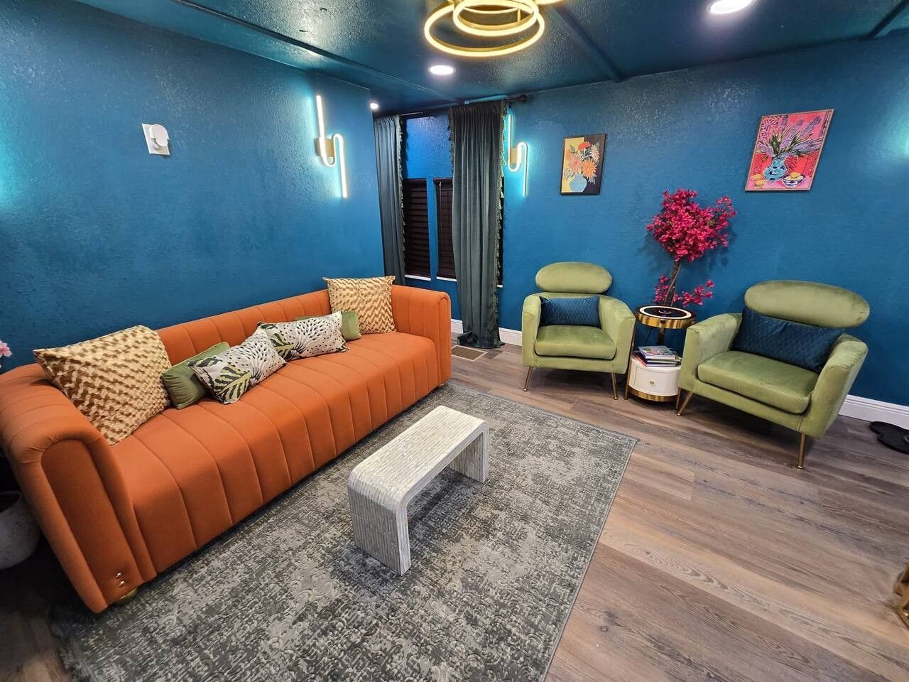 A living room with a sofa, two armchairs, a coffee table, and a small side table with decorative items.