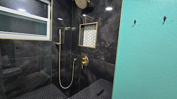 Une salle de bain avec une douche, des toilettes et une fenêtre.
