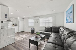 A modern kitchen with white cabinetry, a built-in oven, and a stainless steel range hood. - 3-bedroom apartment with AC near Brickell/Downtown (Miami)