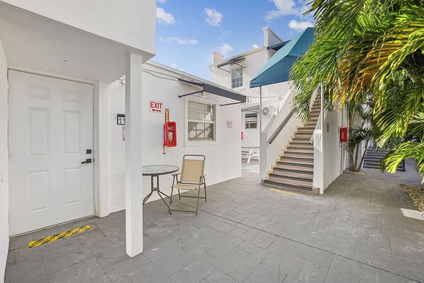 A building with an exit sign, a staircase, and a table with a chair. - 3-bedroom apartment with AC near Brickell/Downtown (Miami)