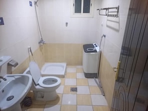 A small bathroom with a toilet, bidet, and a sink. - Fouad Ali Al-Ezzi for Serviced Apartments Al-Sail Road (Taif)