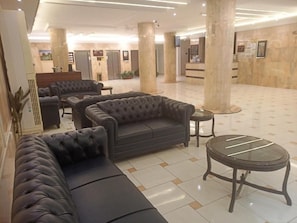 A lobby with a seating area, a reception desk, and a tiled floor. - Fouad Ali Al-Ezzi for Serviced Apartments Al-Sail Road (Taif)