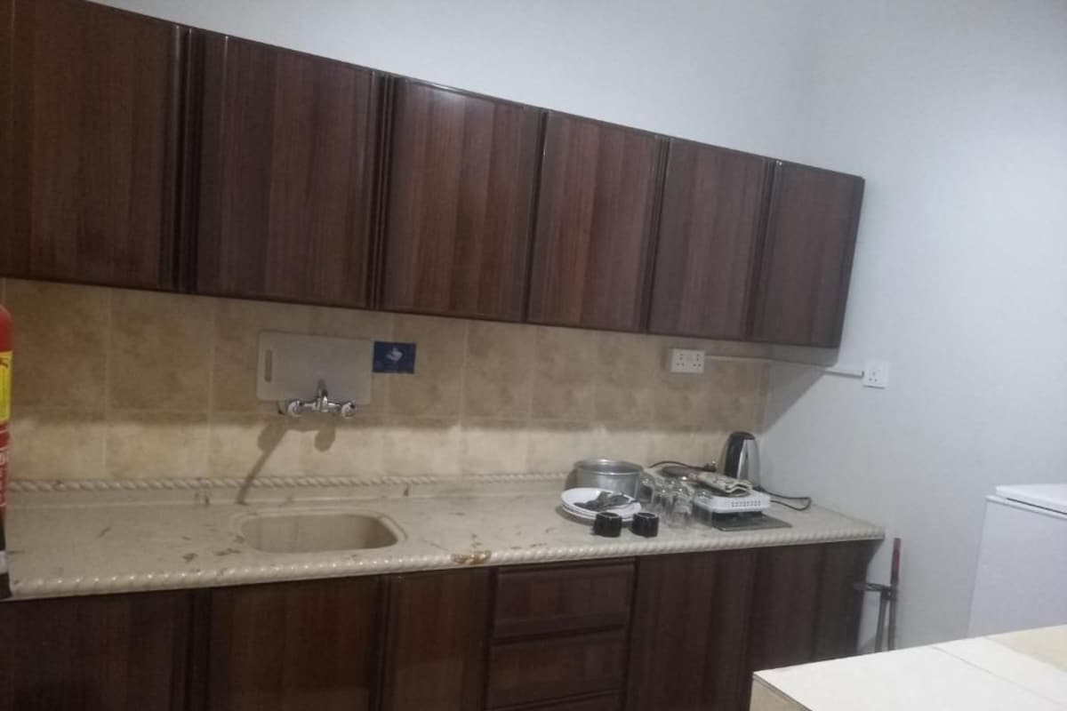 A kitchen with wooden cabinets, a sink, and a countertop with various items.