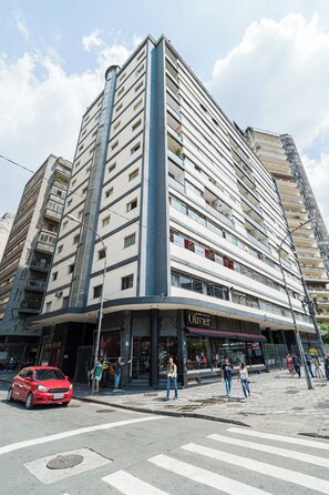 Ein mehrgeschossiges Gebäude mit einer Ladenfläche im Erdgeschoss, einschließlich eines sichtbaren Schaufensters mit Beschilderung.