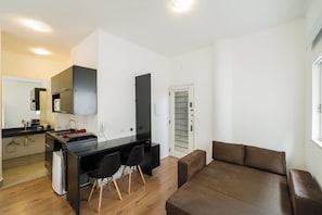 A modern apartment with a kitchenette, a dining area, and a living space. - Esther by Bhomy (São Paulo)