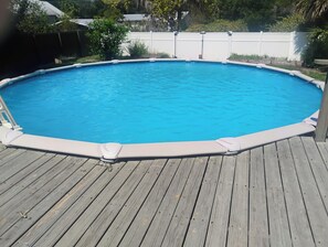A rectangular above-ground pool with a wooden deck surrounding it. - Spacious studio apartment centrally located in Perry (Perry)