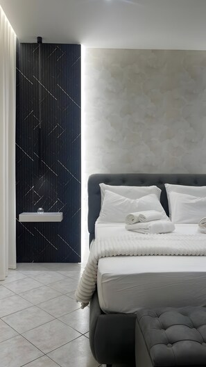 A modern bedroom with a bed, a bedside table, and a wall with a geometric pattern. - Apartment 'Essential Suite Catania - Luxury' with Balcony, Wi-Fi and Air Conditioning (Catania)