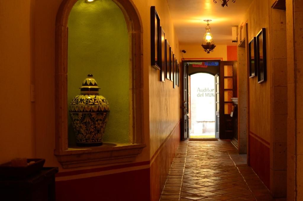 A hallway with a tiled floor, a decorative vase, and a sign reading 'Auditorium dei Muni.'