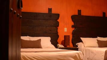 Een kamer met twee bedden, houten hoofdeinden en een telefoon op een nachtkastje.