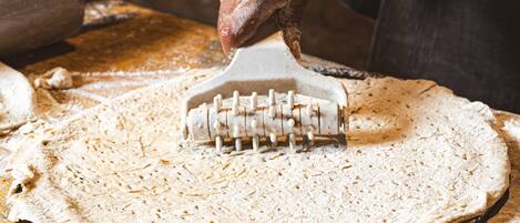 A hand using a pastry brush on a dough surface.