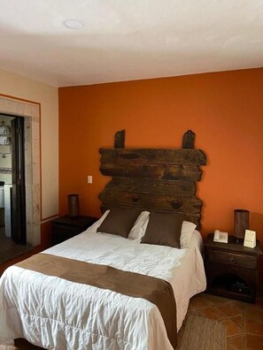 A bedroom with a wooden headboard, a bed with white bedding, a nightstand, and a bedside table with a lamp. - Hotel Boutique Tierra Magica (Tequila)