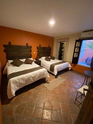 A room with two beds, a small table, and a television. - Hotel Boutique Tierra Magica (Tequila)