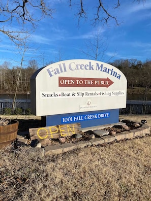 Bordje voor Fall Creek Marina, met de mededeling dat het open is voor publiek, en snacks, boot- en schepenverhuur en hengelsportartikelen aanbiedt.