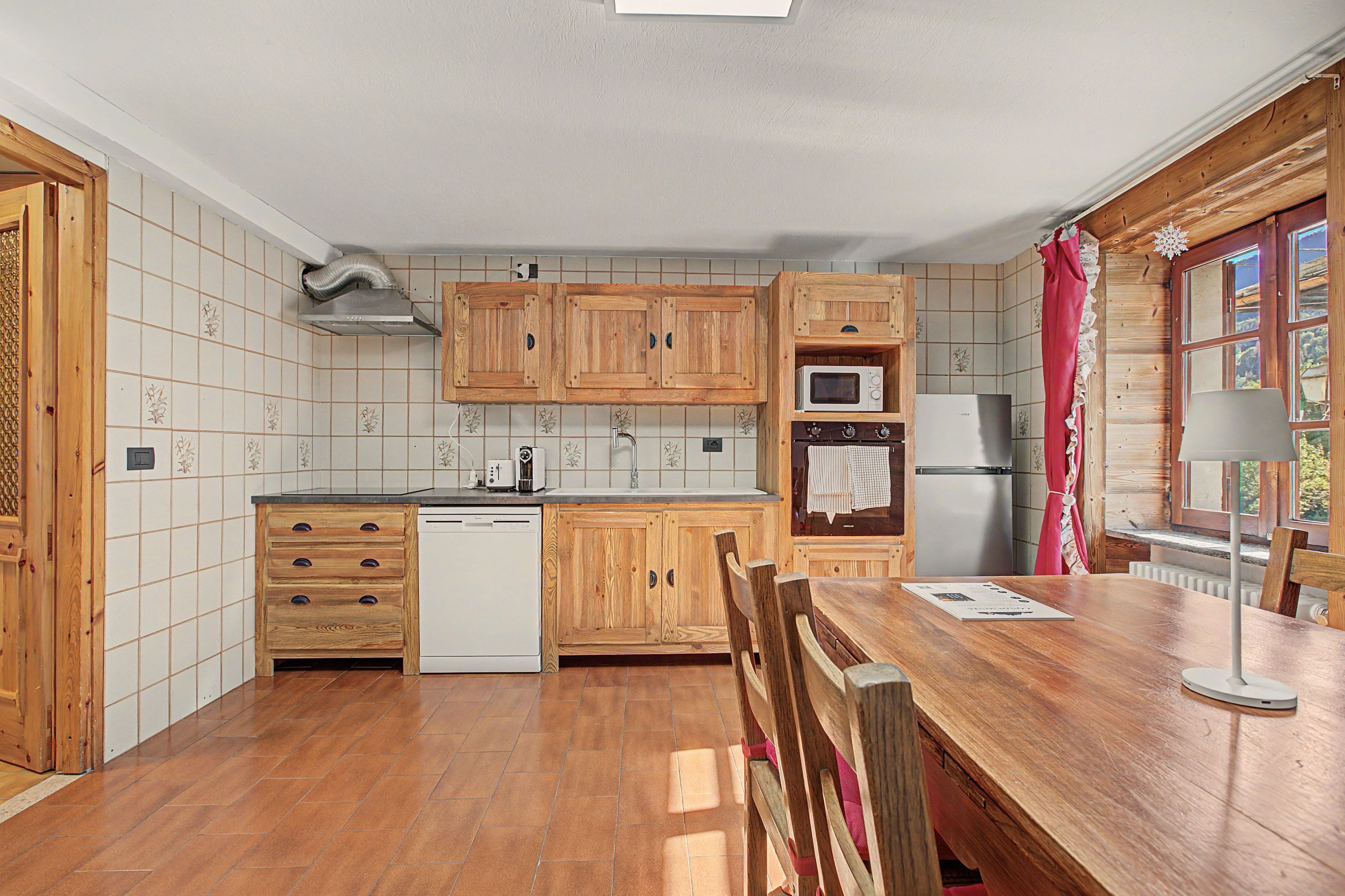 A kitchen with wooden cabinets, a dishwasher, a microwave, and a refrigerator.
