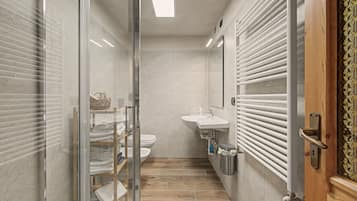 Ein modernes Badezimmer mit Duschkabine aus Glas, Holzboden, weißem Waschbecken und Handtuchhalter.