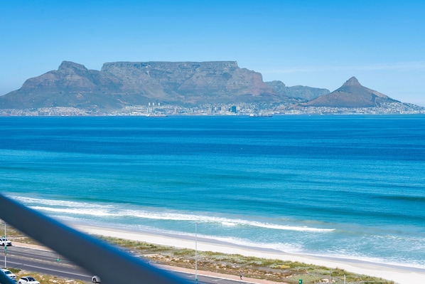 A coastal cityscape with a prominent mountain in the background. - The Bay A801 (Cape Town)