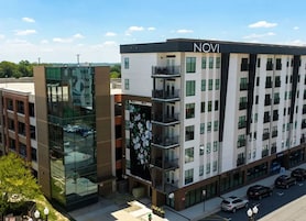 A multi-story hotel with a modern design, featuring balconies and large windows.