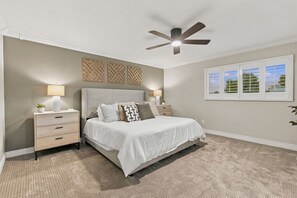 A bedroom with a bed, nightstands, a ceiling fan, wall art, and a window. - 3BR Scottsdale Retreat, Pool, Near Old Town (Scottsdale)