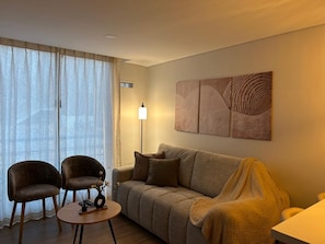A living room with a sofa, two armchairs, a coffee table, and a floor lamp. - A Cozy, Stylish Stay in the Heart of Bogotá (Bogotá)