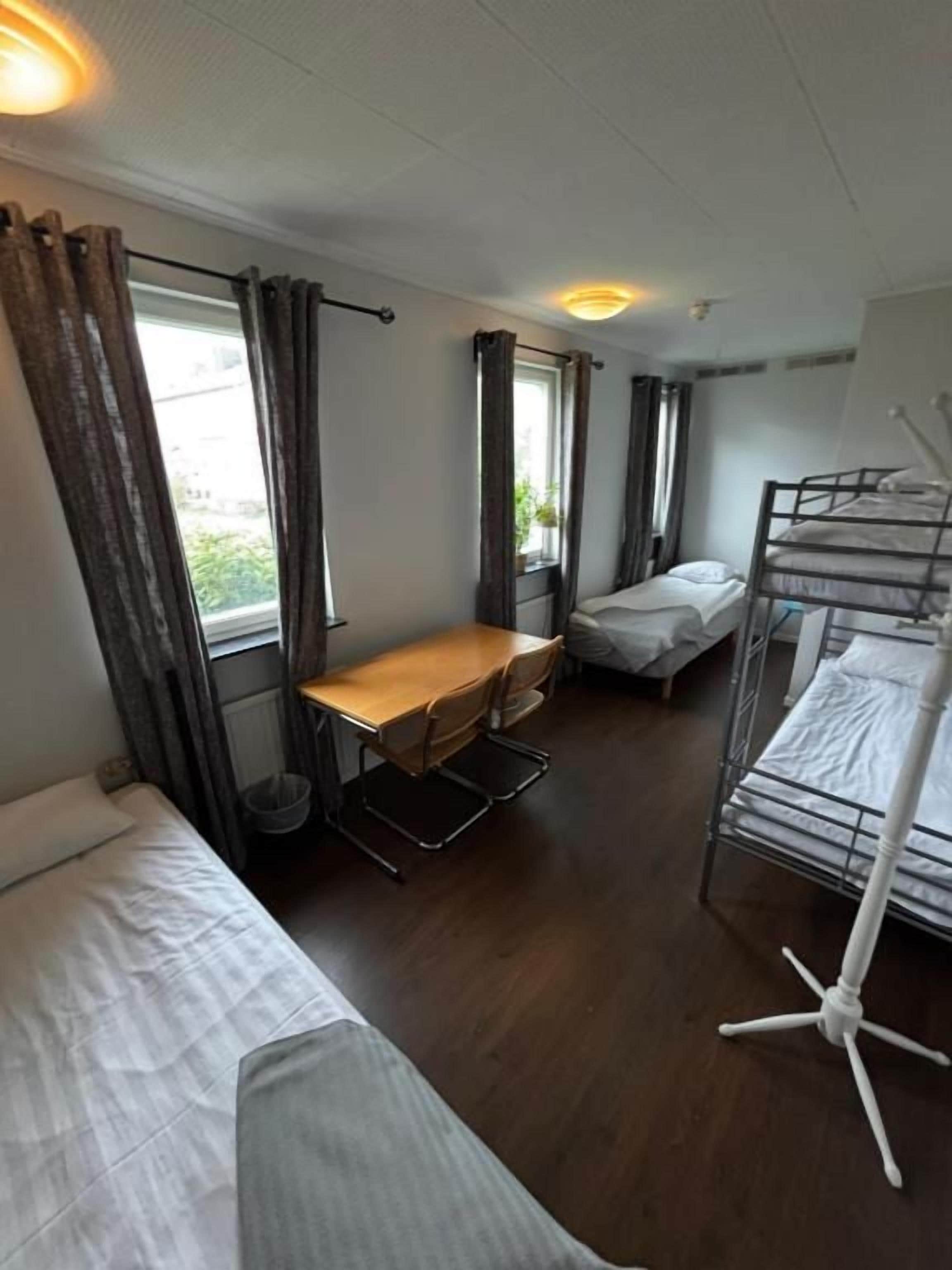 A compact room with a bunk bed, a desk, and a chair.