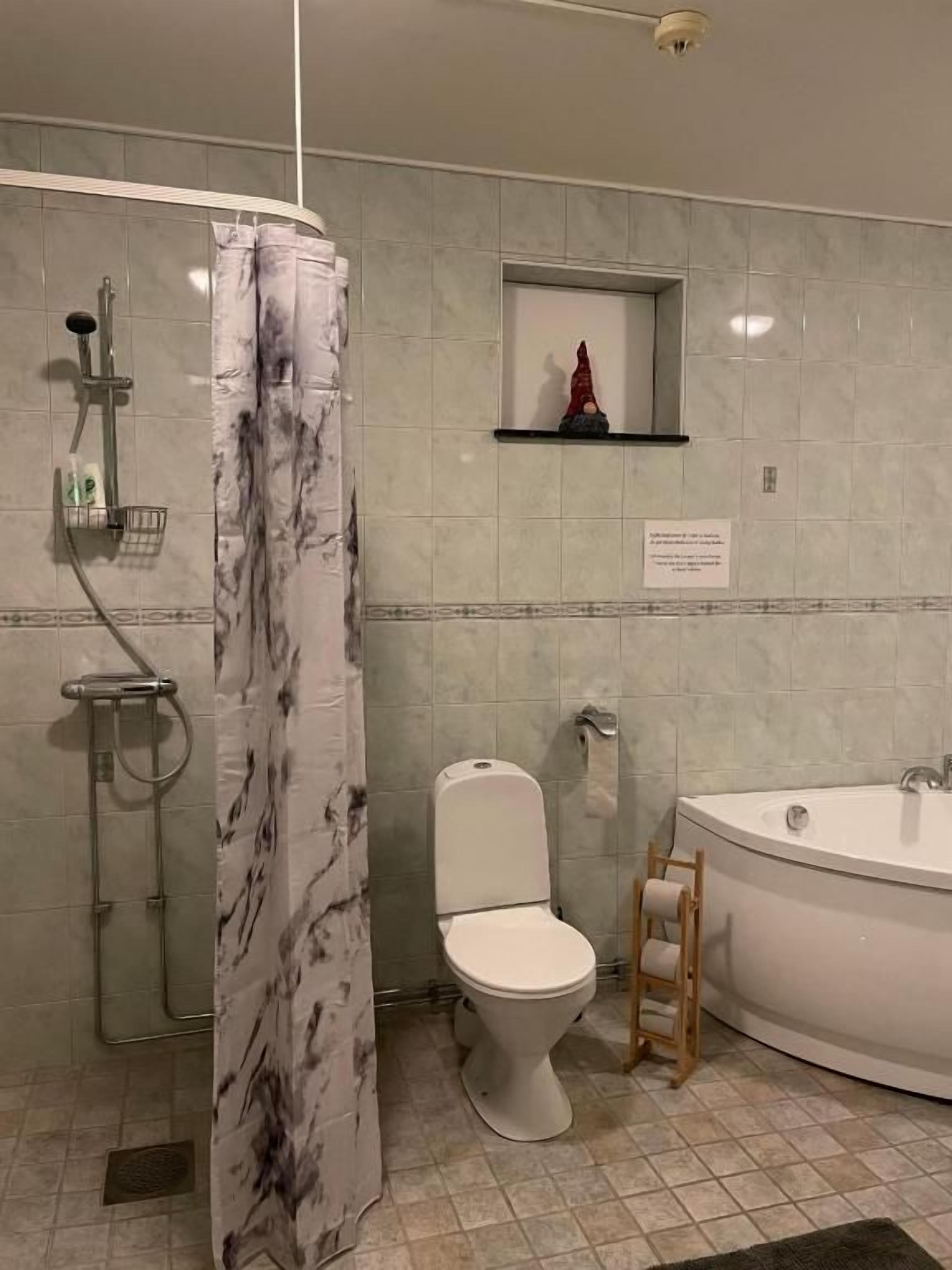 A bathroom with a shower, toilet, and bathtub.