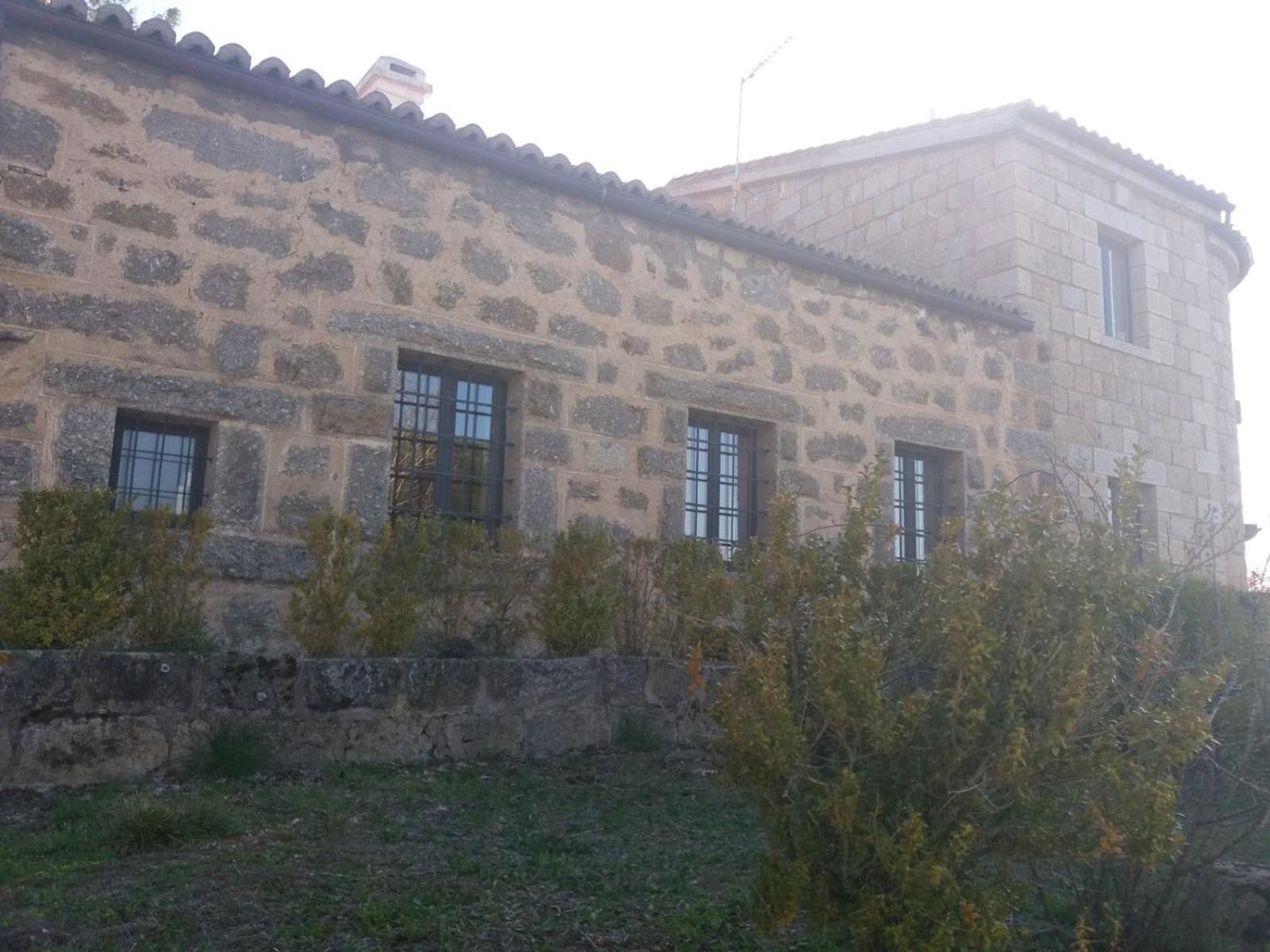 A stone building with multiple windows and a flat roof.